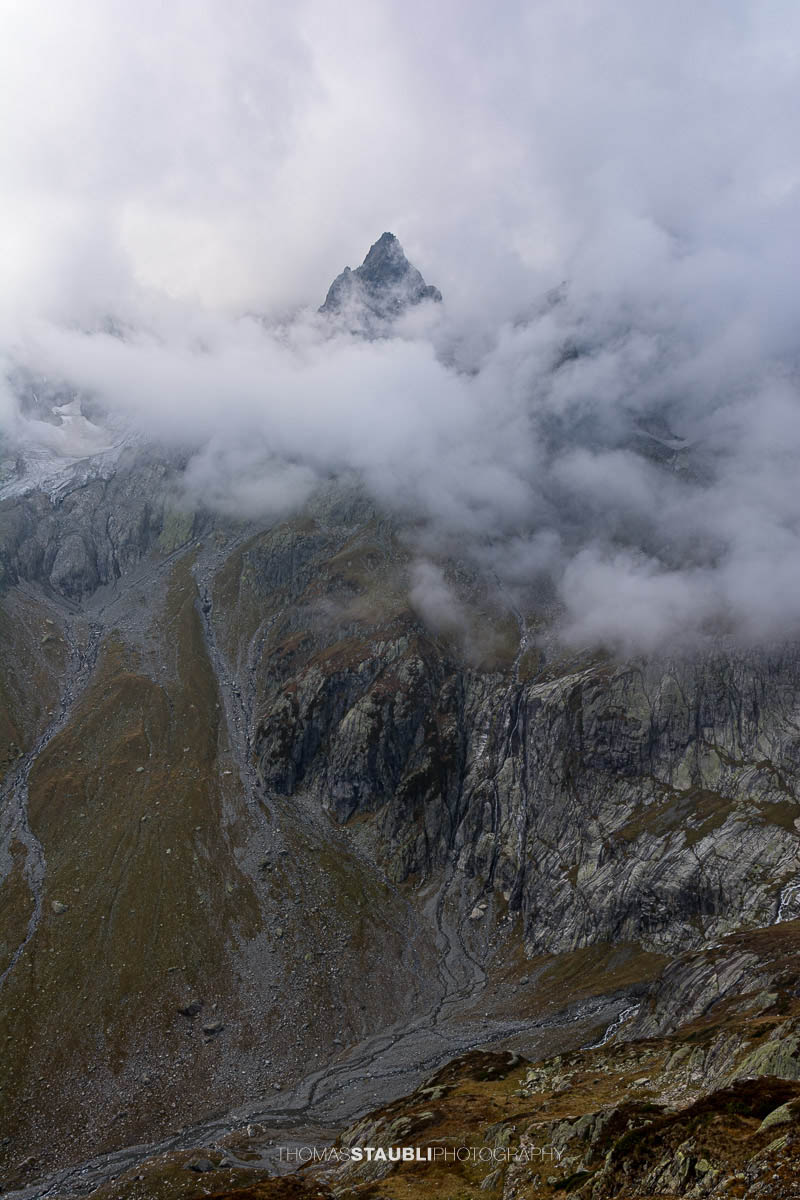 Blick zum Wendenhorn in den Urner Alpen, schroffe Berggipfel von dichtem Nebel und Wolken umhüllt.