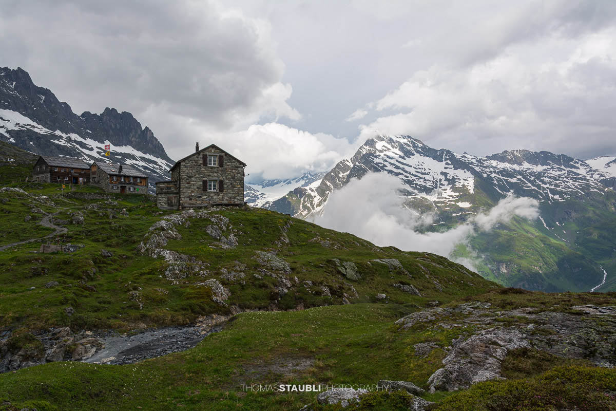 Die Windgällenhütte im Maderanertal, umgeben von Nebelschwaden und den Gipfeln der Urner Alpen.