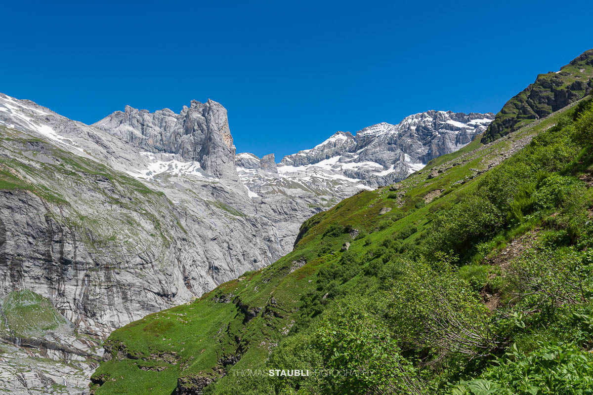 Blick ins hintere Maderanertal mit steilen Felswänden, Wasserfällen, Gletschern und grünen Berghängen im Kanton Uri.