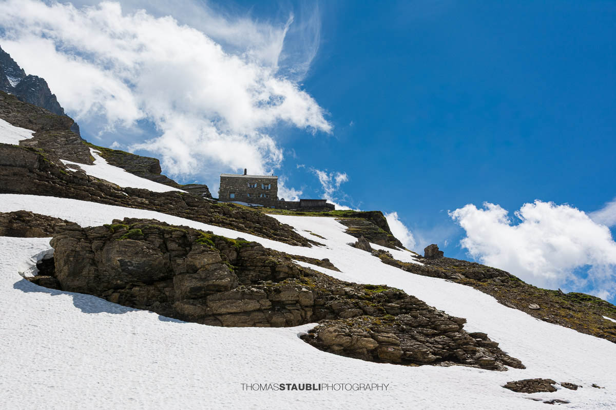 Hüfihütte im Maderanertal mit Schneefeldern und den Urner Alpen im Hintergrund.