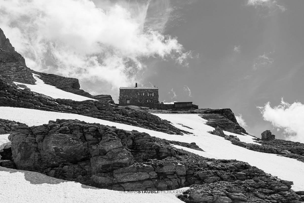 Hüfihütte im Maderanertal mit Schneefeldern und den Urner Alpen im Hintergrund.