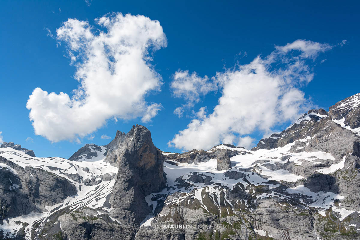 Chalch Schijen im Maderanertal mit Schneefeldern und Felswänden unter blauem Himmel.