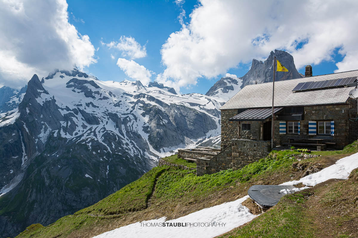 Hüfihütte oberhalb des Maderanertals vor einer beeindruckenden Kulisse aus Gletschern, Felsgipfeln und Schneefeldern.