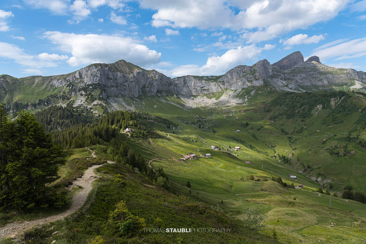 Wanderweg auf der Hüenderegg mit Blick über die Alplandschaft des Schächentals und die Gipfel der Urner Alpen.