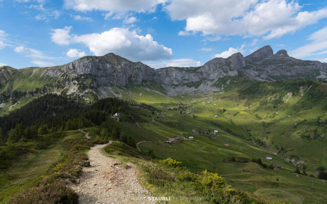 Wanderweg auf der Hüenderegg mit Blick über die Alplandschaft des Schächentals und die Gipfel der Urner Alpen.