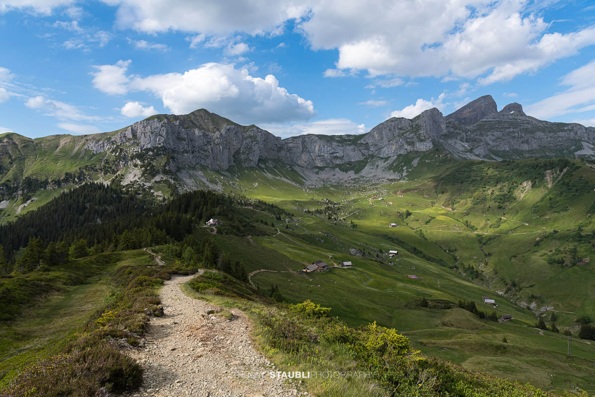 Wanderweg auf der Hüenderegg mit Blick über die Alplandschaft des Schächentals und die Gipfel der Urner Alpen.