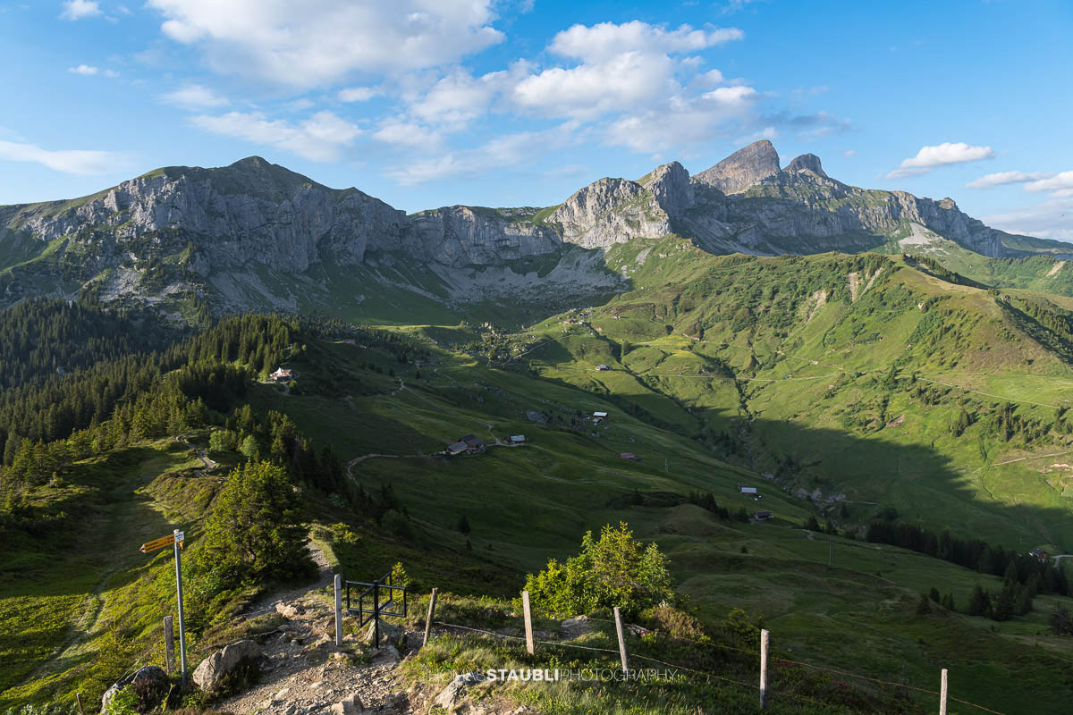 Wanderweg auf der Hüenderegg mit Blick über die Alplandschaft des Schächentals und die Gipfel der Urner Alpen.