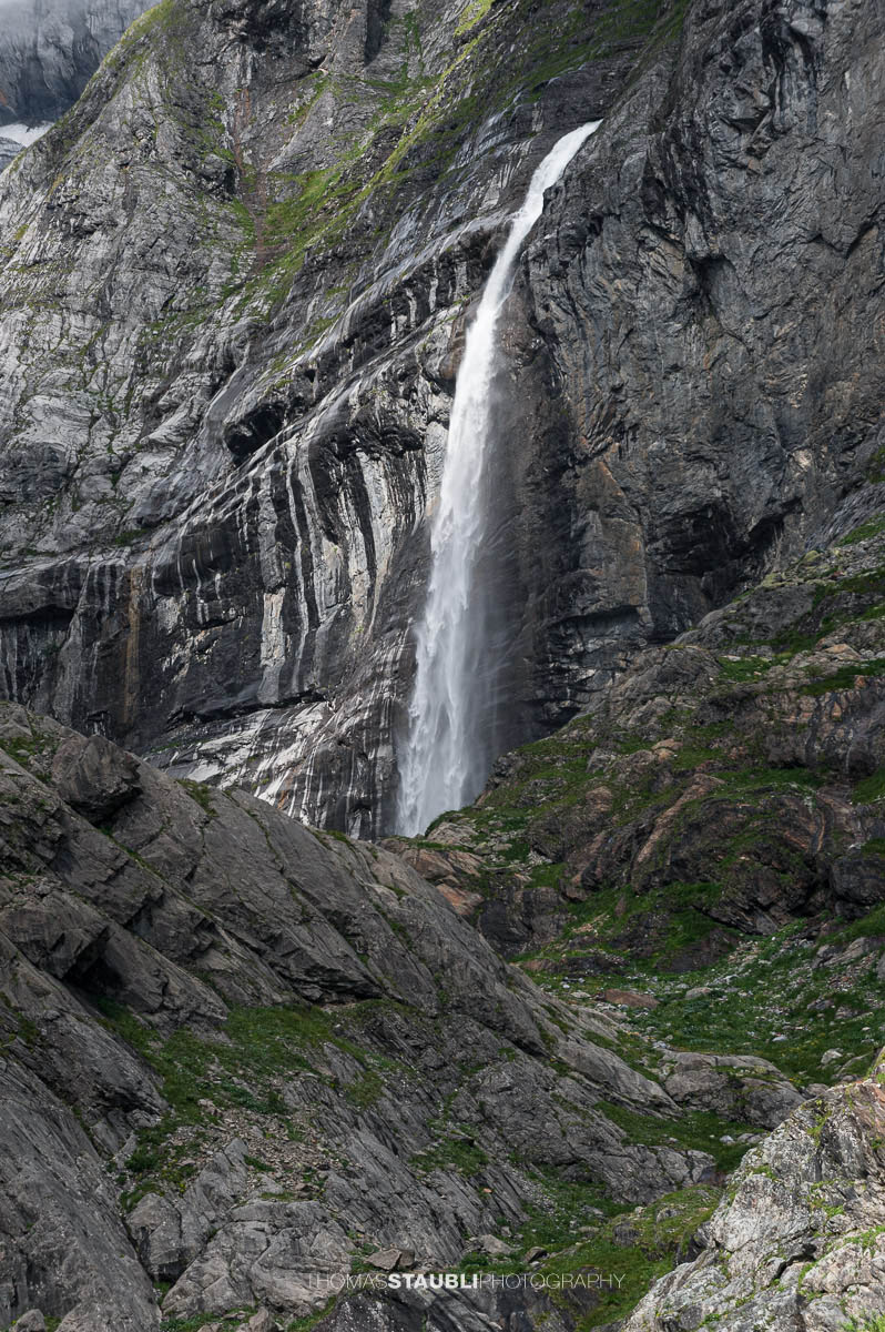 Wasserfall bei Unter Hüfi im Maderanertal vor steilen Felswänden und alpiner Berglandschaft.