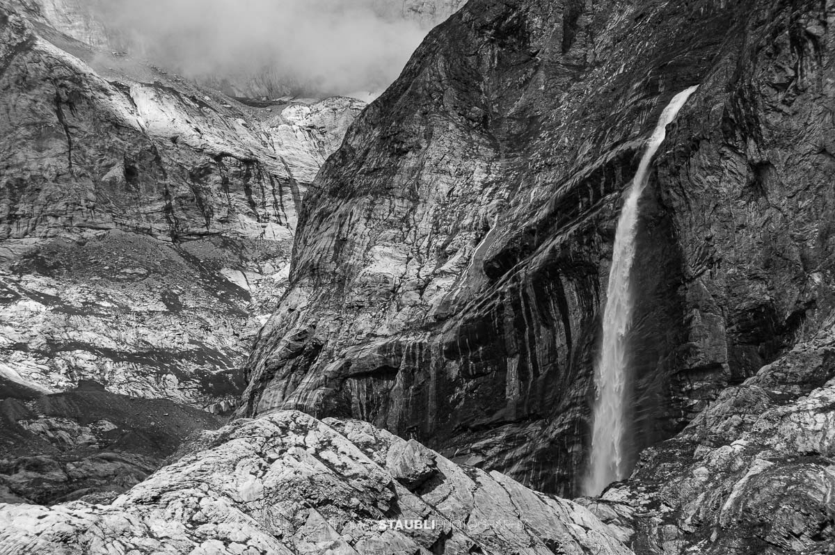 Wasserfall bei Unter Hüfi im Maderanertal vor steilen Felswänden und alpiner Berglandschaft.