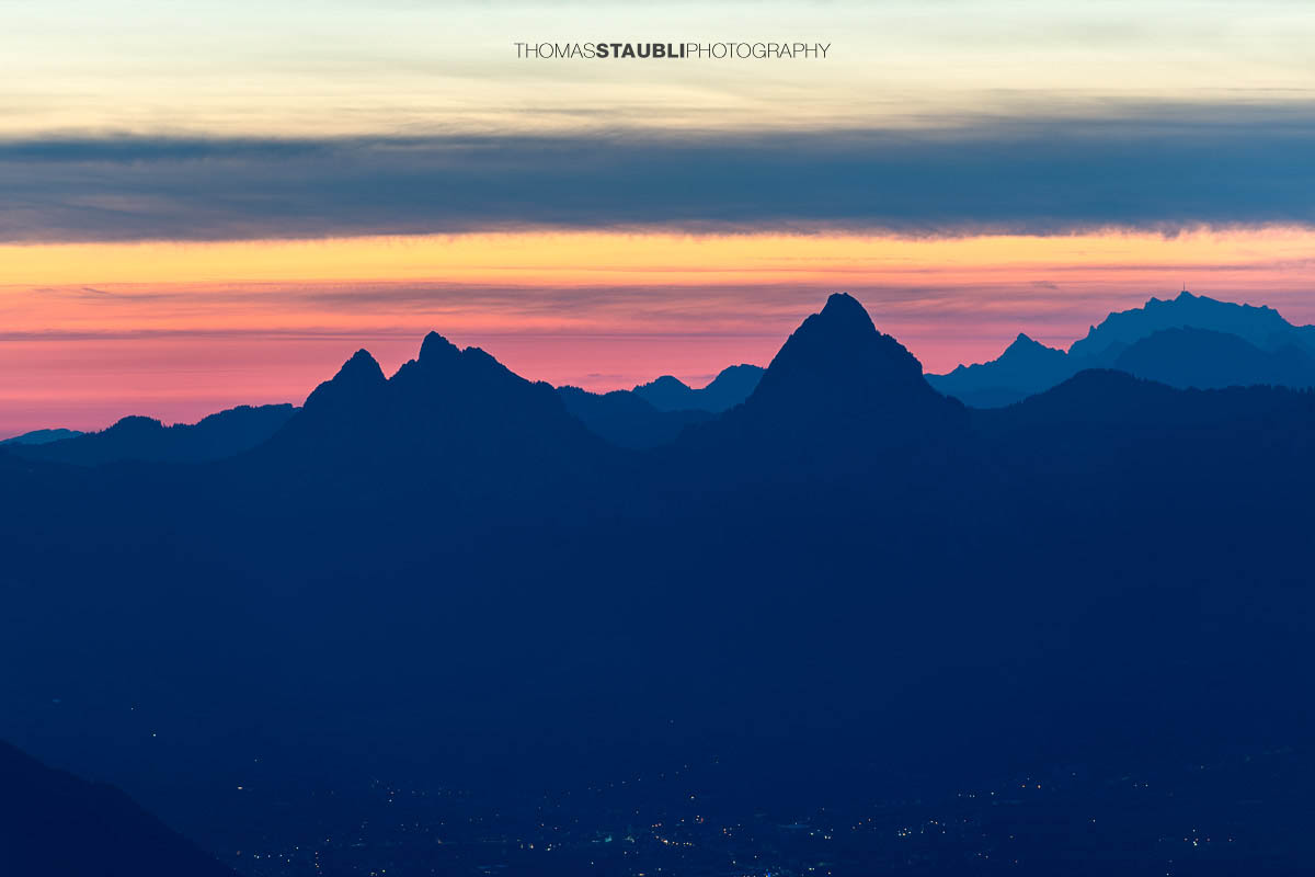 Morgenrot hinter den Mythen mit leuchtendem Morgenhimmel, aufgenommen vom Musenalper Grat in Nidwalden.