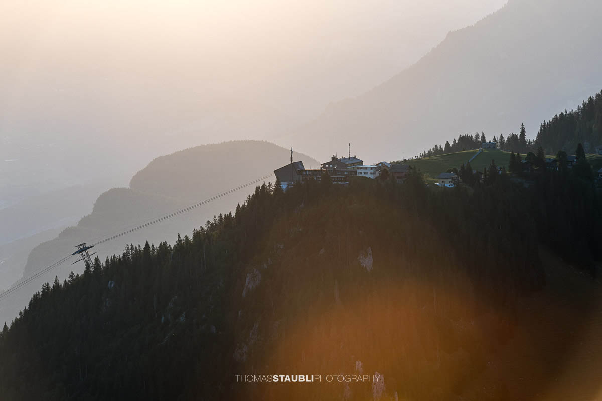 Bergstation Klewenalp im warmen Morgenlicht mit gestaffelten Bergketten der Zentralschweiz im Hintergrund.
