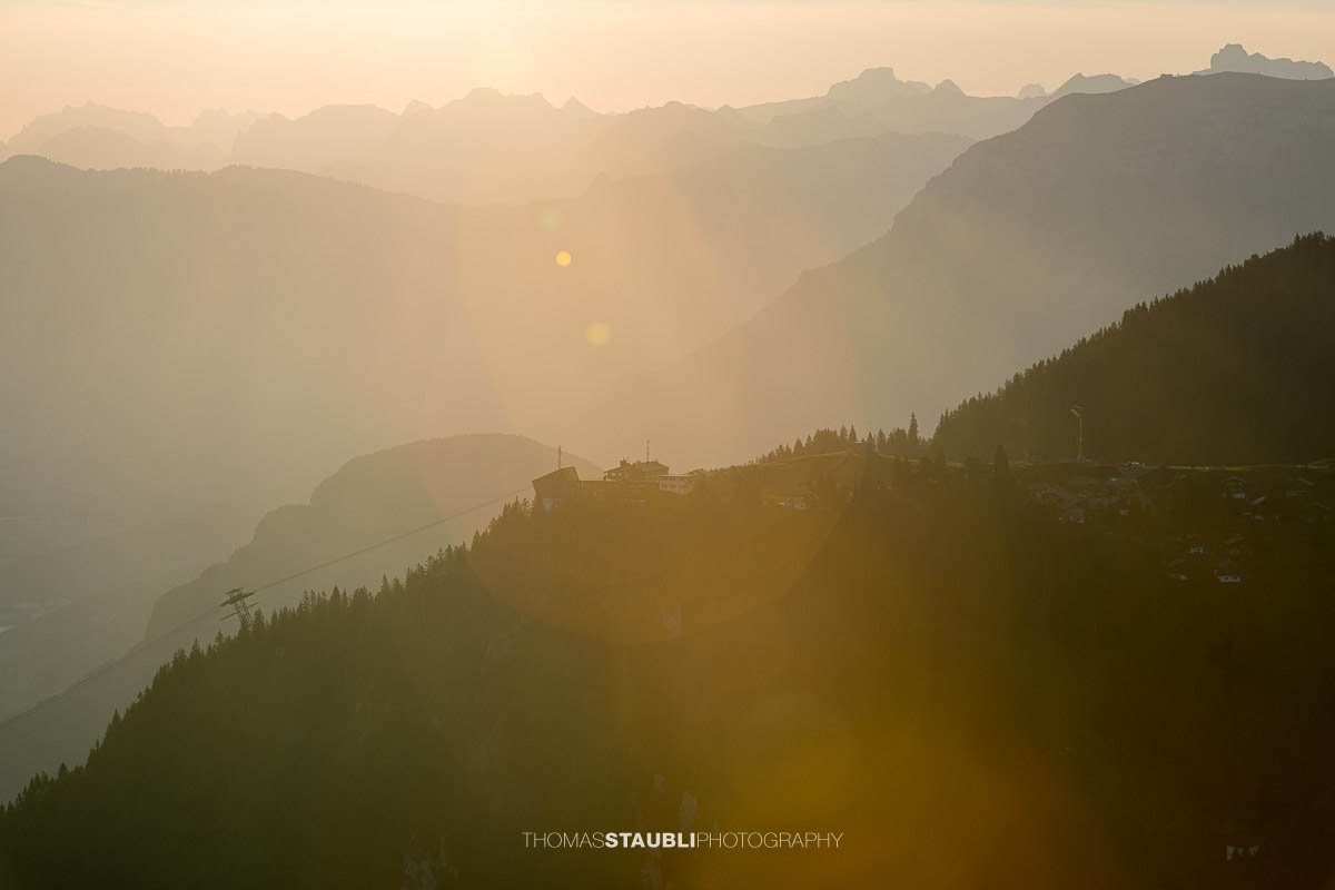 Bergstation Klewenalp im warmen Morgenlicht mit gestaffelten Bergketten der Zentralschweiz im Hintergrund.