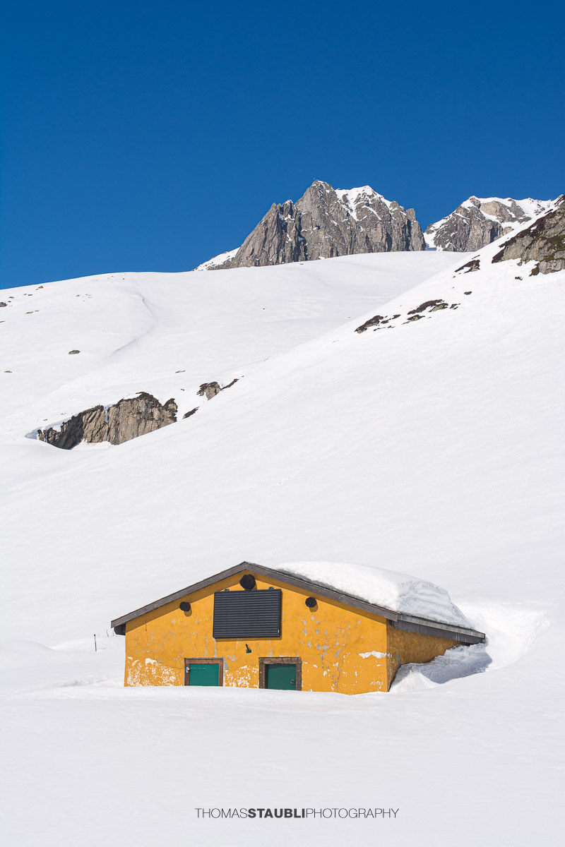 tief verschneite Alphütte auf dem Oberalppass