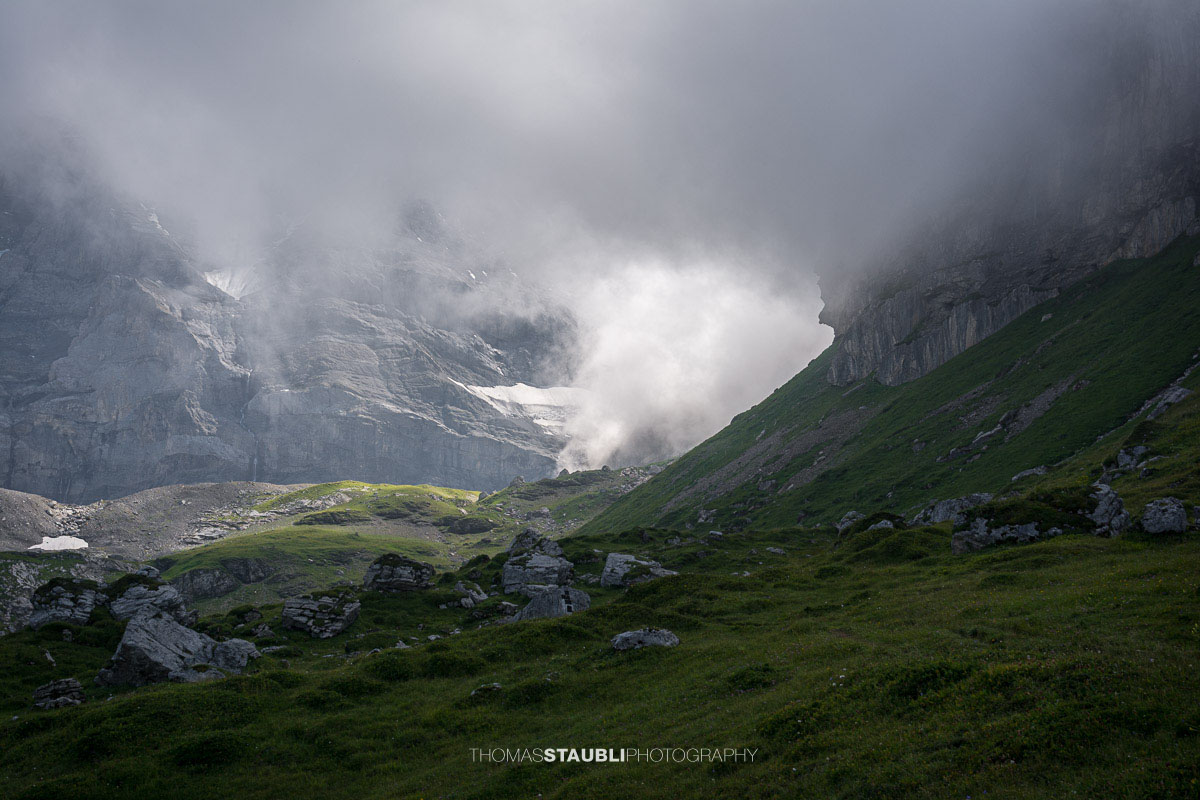 Berglandschaft im Griess am Klausenpass mit Wolken und felsigen Berghängen.