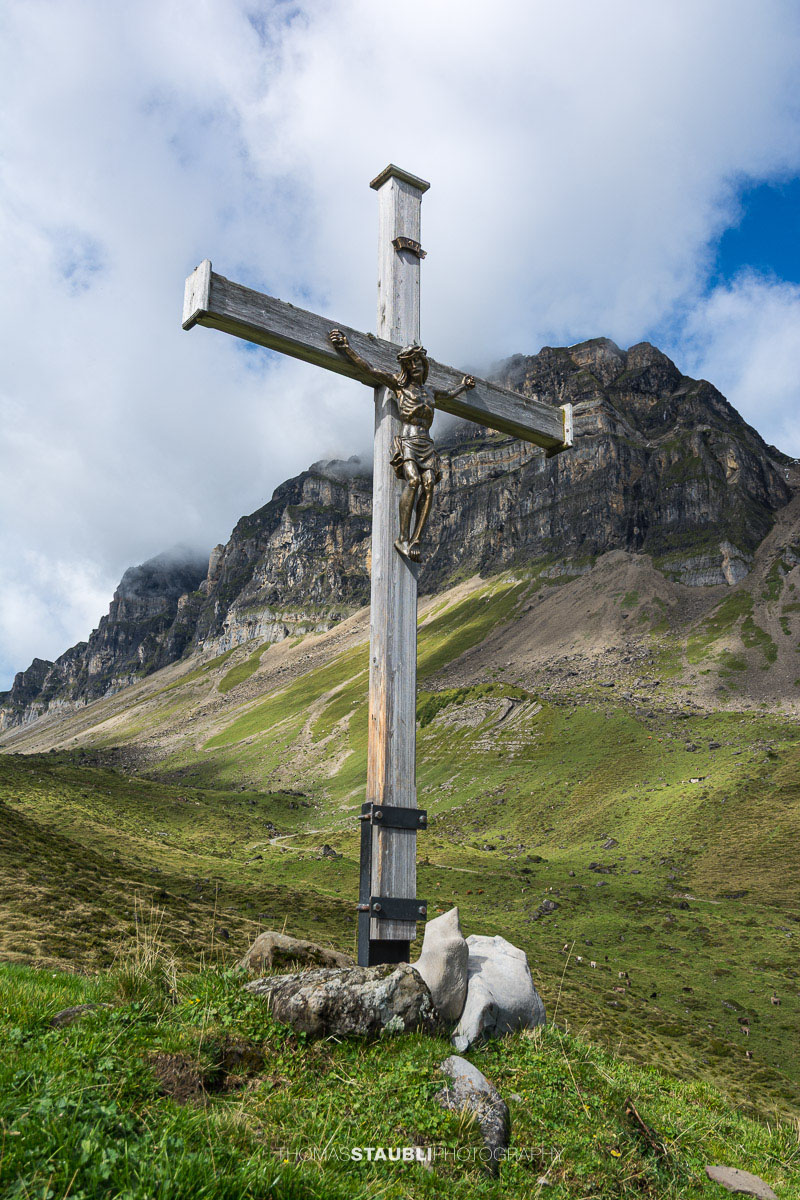 Bergkreuz auf der Seenalp vor der imposanten Felslandschaft im Kanton Uri.