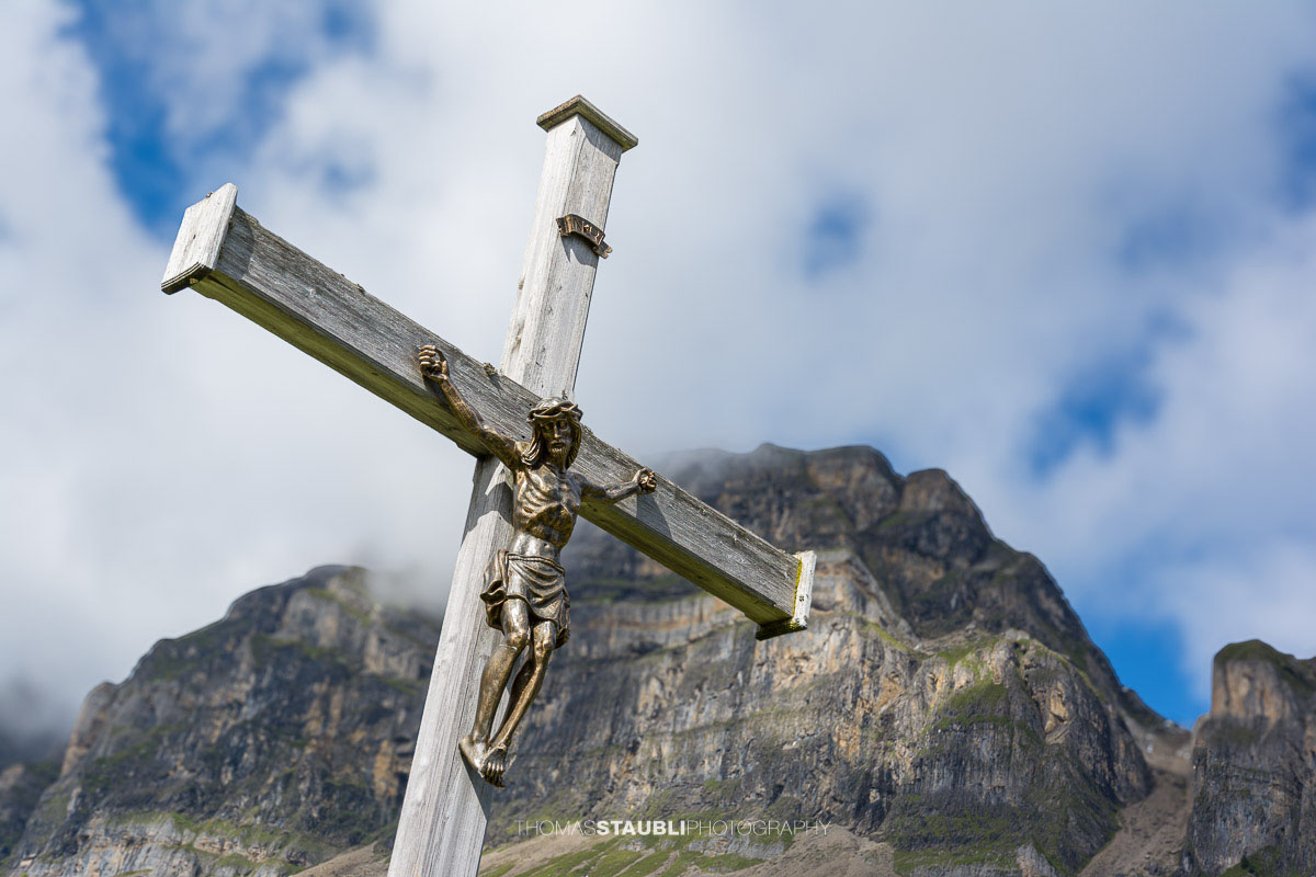 Bergkreuz auf der Seenalp vor der imposanten Felslandschaft im Kanton Uri.