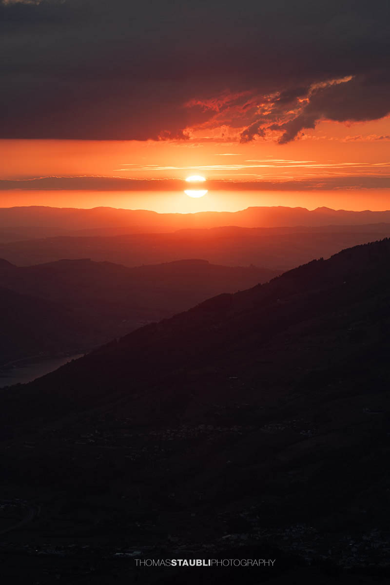 Rote Abendstimmung von der Rotenflue mit der untergehenden Sonne über der Jurakette.