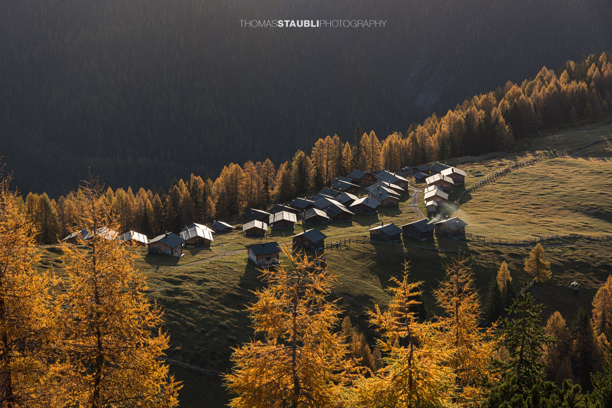 die ersten herbstlichen Sonnenstrahlen erreichen die Wiesner Alp mit den traditionellen Alphütten.