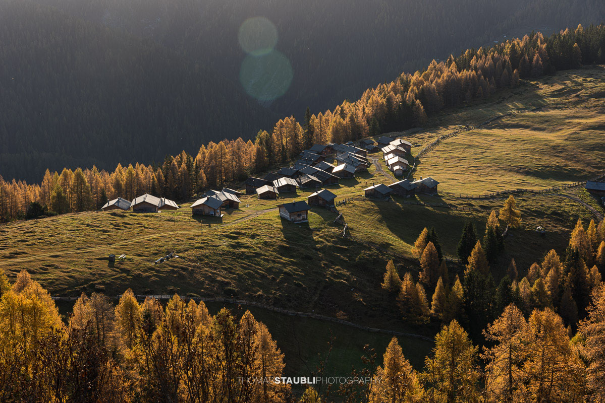 die ersten herbstlichen Sonnenstrahlen erreichen die Wiesner Alp mit den traditionellen Alphütten.