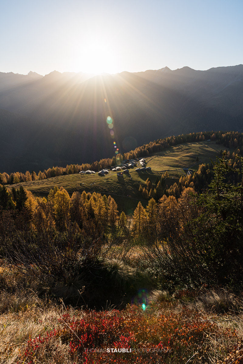 die ersten herbstlichen Sonnenstrahlen erreichen die Wiesner Alp mit den traditionellen Alphütten.