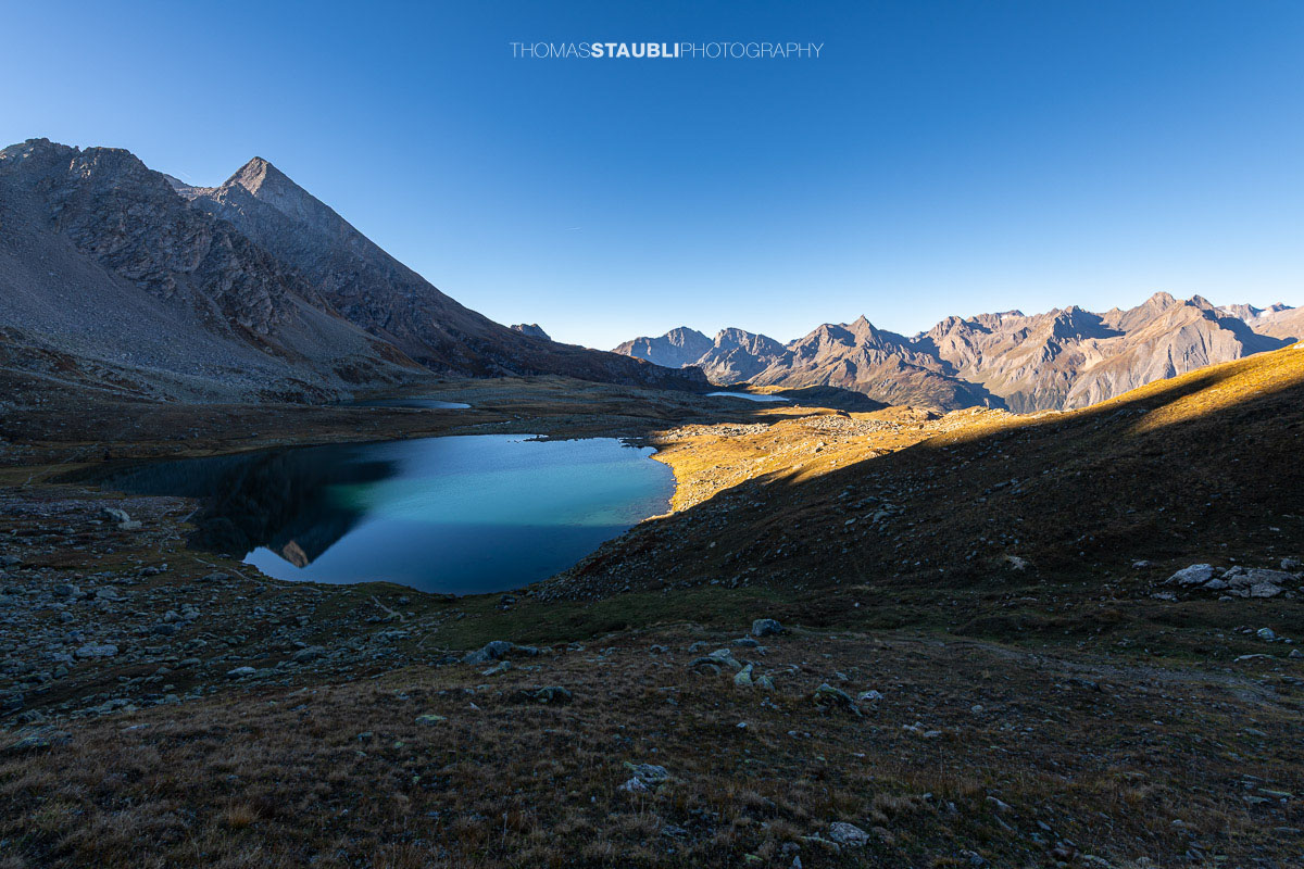 Blick über den Bergsee Laghi Boden auf der italienischen Seite des Passo San Giacomo, umgeben von einer kargen alpinen Berglandschaft.