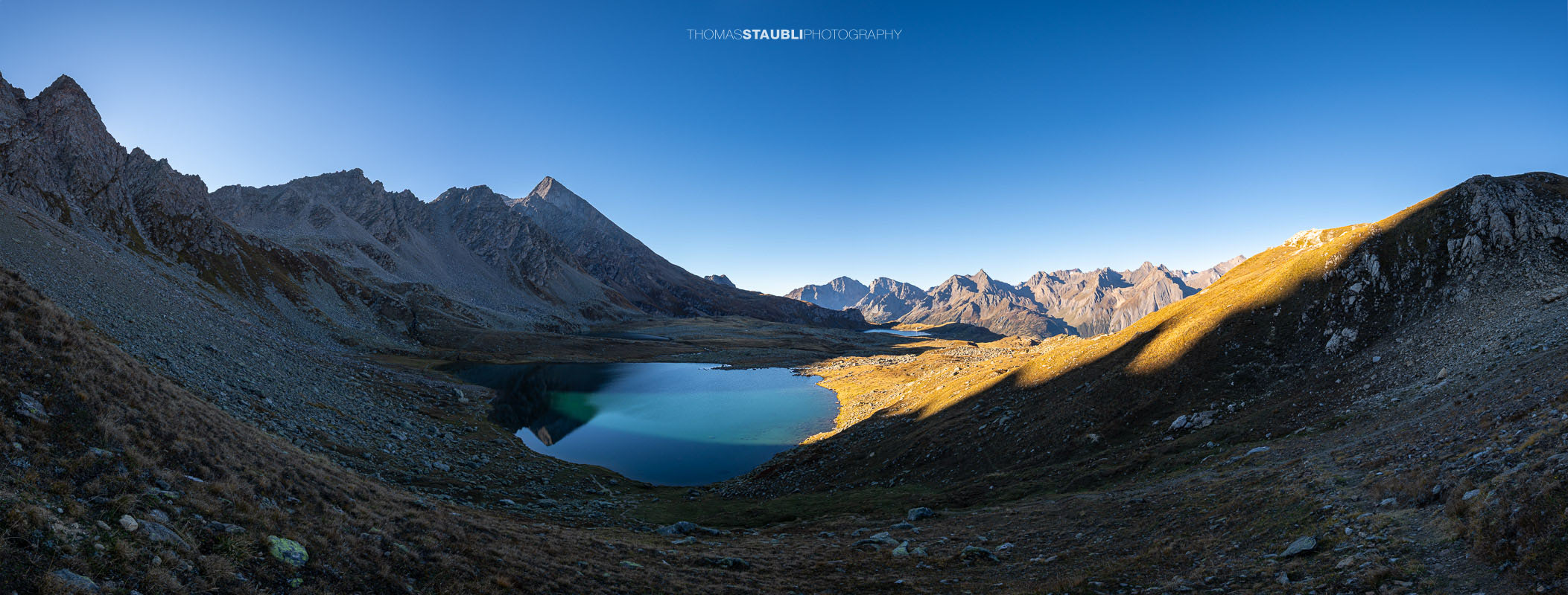 Blick über den Bergsee Laghi Boden auf der italienischen Seite des Passo San Giacomo, umgeben von einer kargen alpinen Berglandschaft.