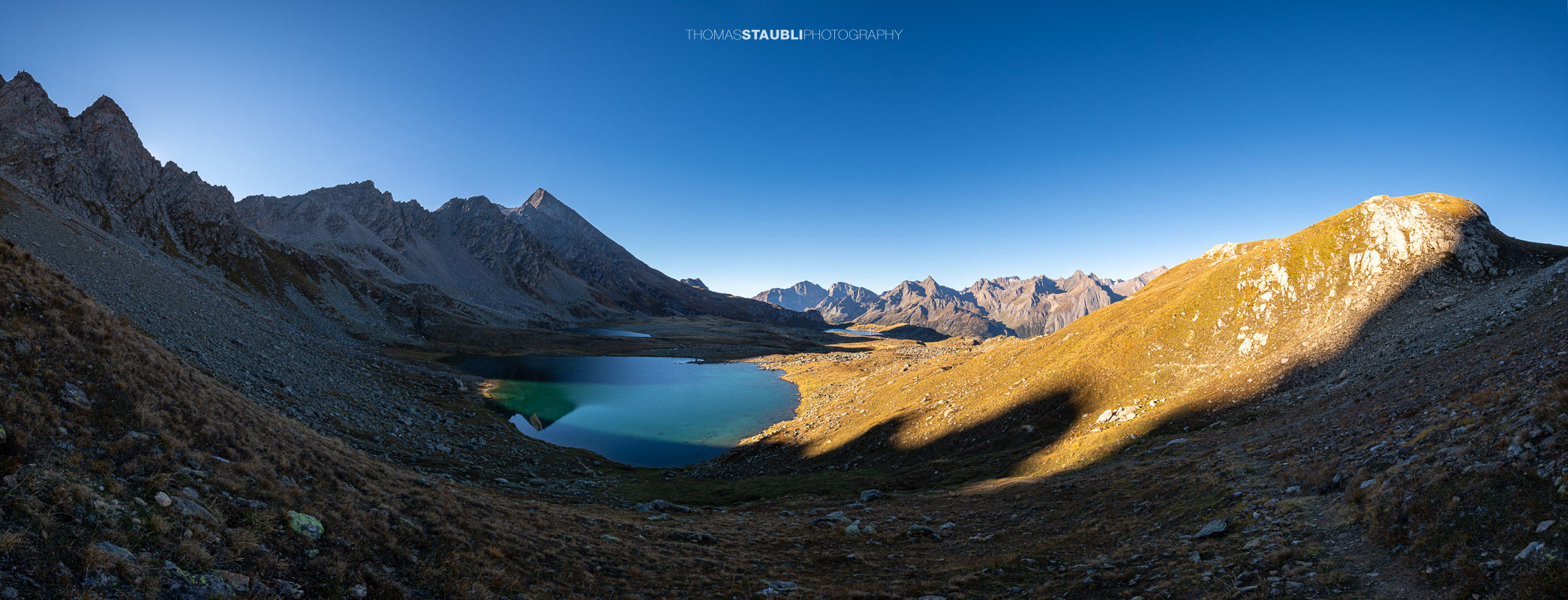 Blick über den Bergsee Laghi Boden auf der italienischen Seite des Passo San Giacomo, umgeben von einer kargen alpinen Berglandschaft.